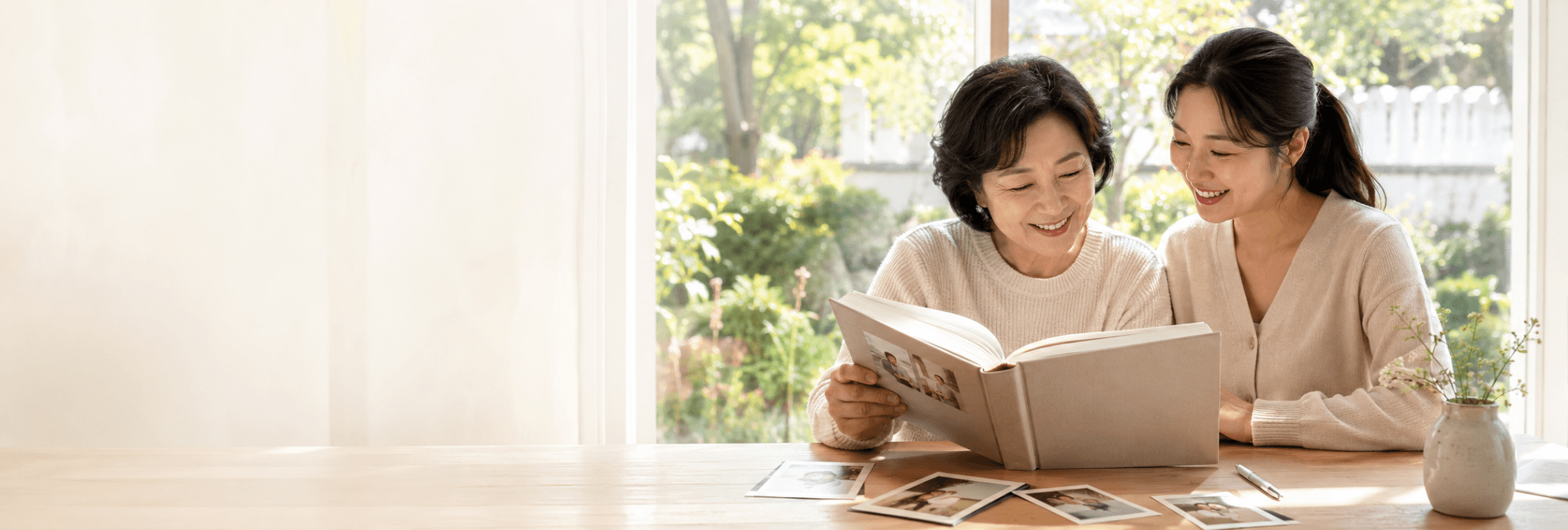 엄마와 딸이 함께 가족사진이 담긴 인생책을 보는 모습